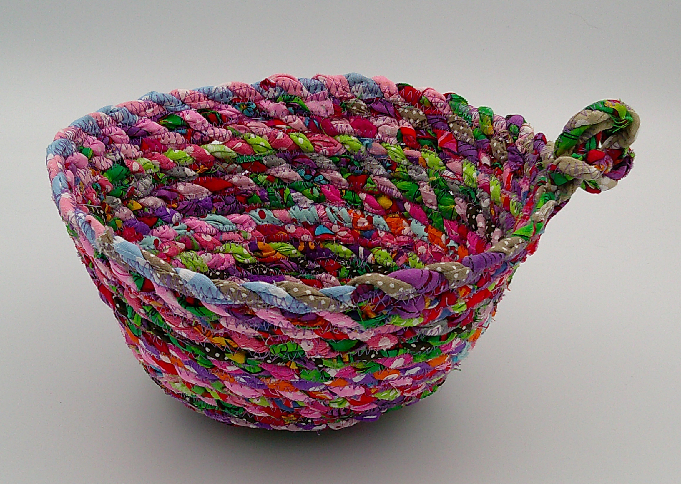 This view is looking at the fabric bowl from the side, showing all the colors of fabric scraps and another view of the knot. This view is looking at the fabric bowl from the side, showing all the colors of fabric scraps and another view of the knot.